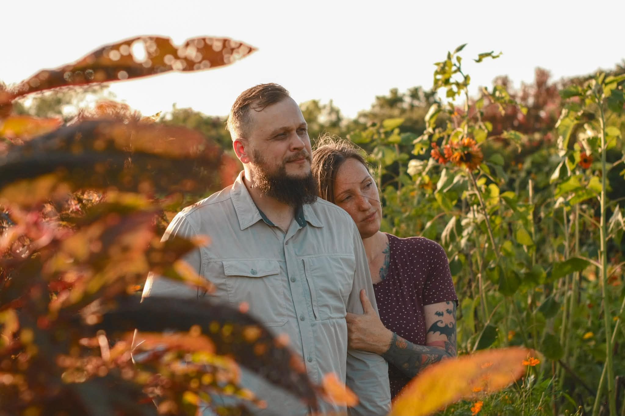 Jordan and Nicole Moulton together among sunflowers in the evening light